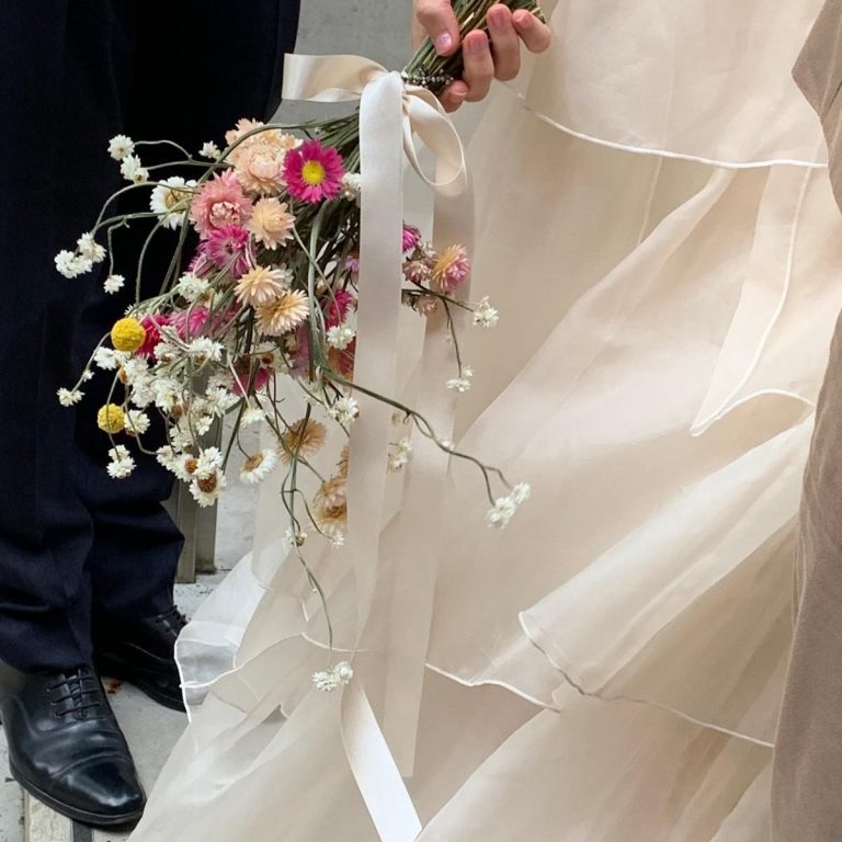 Close-up of a bride's bouquet in Cheshire, with the wedding dress in the background.